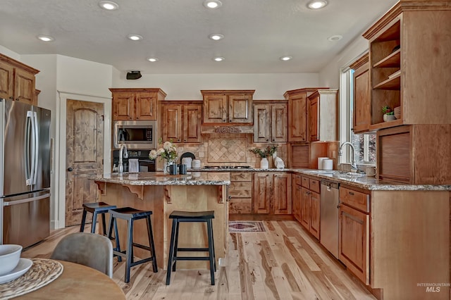 352 N Panorama Pl, Boise, ID 83702 - kitchen featuring appliances with stainless steel finishes, stone counters, a kitchen island with sink, a breakfast bar, and recessed lighting