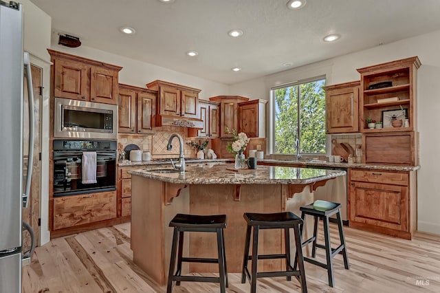 352 N Panorama Pl, Boise, ID 83702 - kitchen featuring stainless steel appliances, an island with sink, recessed lighting, light wood-style flooring, and light stone countertops