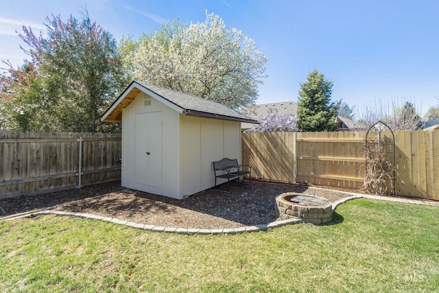 view of shed with an outdoor fire pit and a fenced backyard