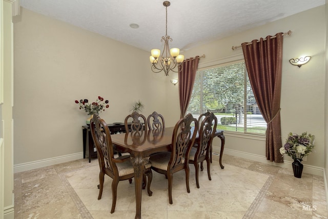 dining room with an inviting chandelier, baseboards, and a textured ceiling