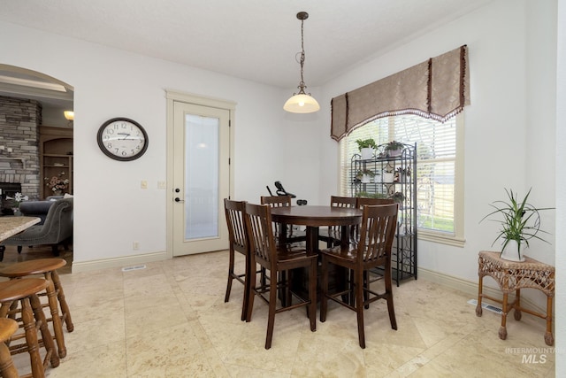 dining area with arched walkways and baseboards