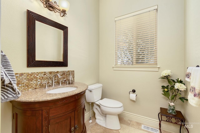 half bathroom featuring tasteful backsplash, visible vents, toilet, vanity, and baseboards