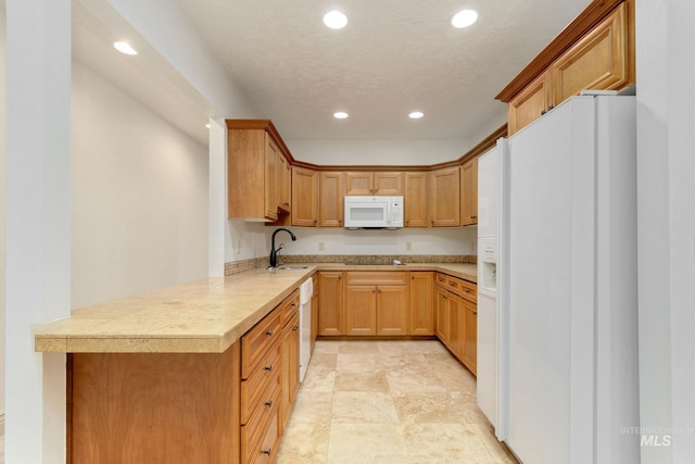 kitchen with recessed lighting, light countertops, a sink, white appliances, and a peninsula