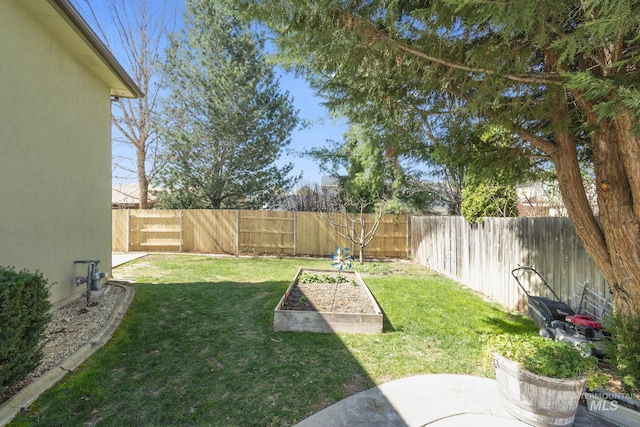 view of yard featuring a fenced backyard and a garden