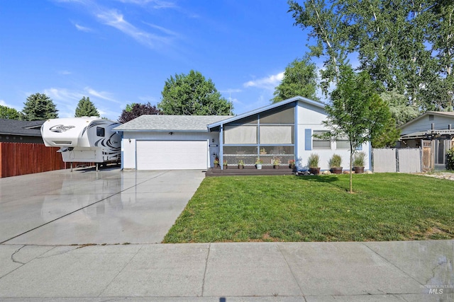 mid-century modern home featuring a garage, concrete driveway, a front lawn, and fence