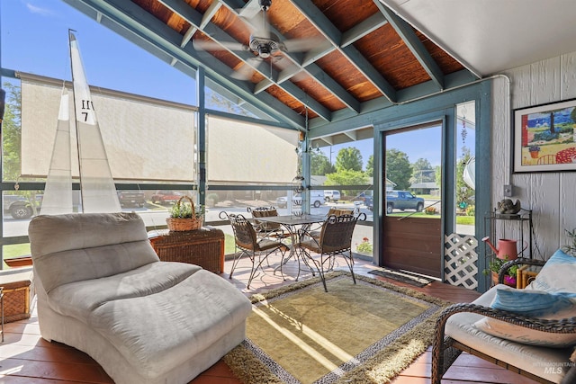 sunroom / solarium featuring vaulted ceiling with beams and a ceiling fan