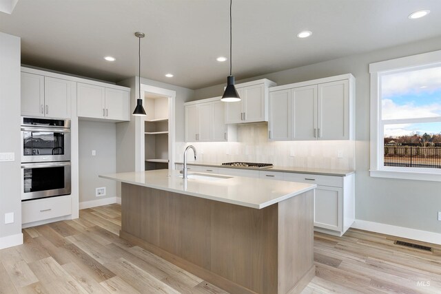 2330 E Monhegan Dr, Eagle, ID 83616 - kitchen featuring a sink, appliances with stainless steel finishes, light wood-type flooring, white cabinetry, and recessed lighting