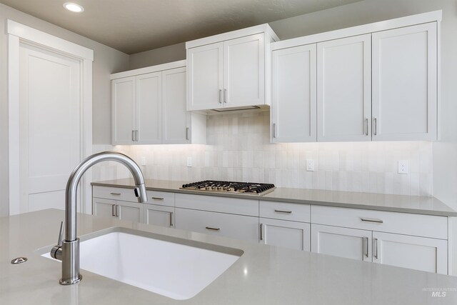 2330 E Monhegan Dr, Eagle, ID 83616 - kitchen with stainless steel gas stovetop, a sink, white cabinetry, tasteful backsplash, and recessed lighting