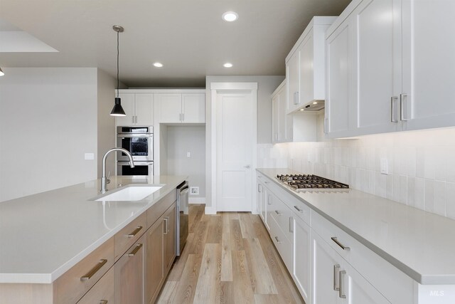2330 E Monhegan Dr, Eagle, ID 83616 - kitchen featuring appliances with stainless steel finishes, a sink, light wood-style flooring, recessed lighting, and tasteful backsplash