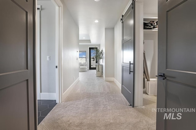 hall with carpet and a barn door