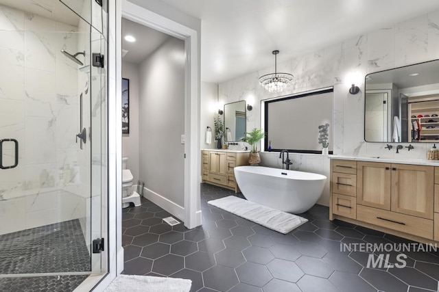 full bathroom with independent shower and bath, a chandelier, vanity, and tile walls