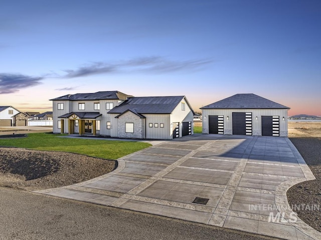 view of front of house featuring an outdoor structure, a lawn, and a garage