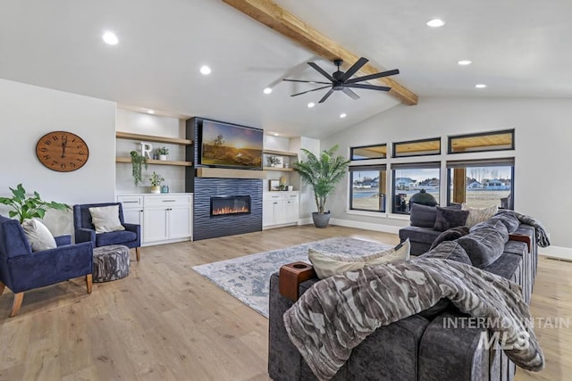 living room featuring a fireplace, built in shelves, vaulted ceiling with beams, light hardwood / wood-style flooring, and ceiling fan