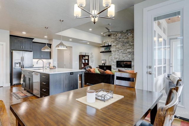 dining room featuring a fireplace, an inviting chandelier, and recessed lighting