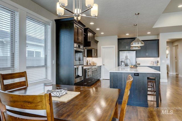 dining room with a notable chandelier, baseboards, dark wood-style flooring, and recessed lighting