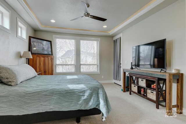 carpeted bedroom with baseboards, a ceiling fan, ornamental molding, a tray ceiling, and recessed lighting