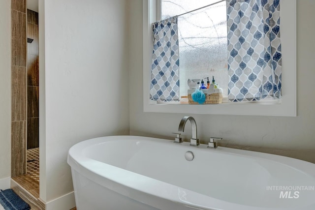 full bathroom with tiled shower and a soaking tub