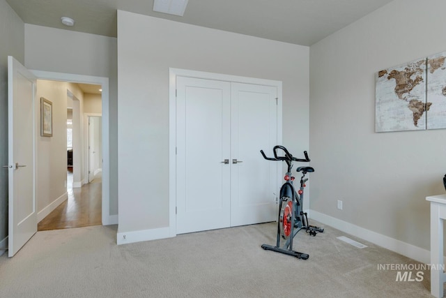 exercise area with carpet floors, visible vents, and baseboards