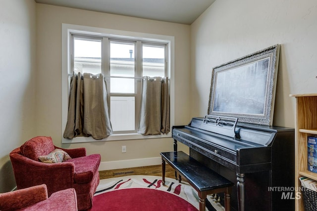 living area with visible vents, baseboards, and wood finished floors