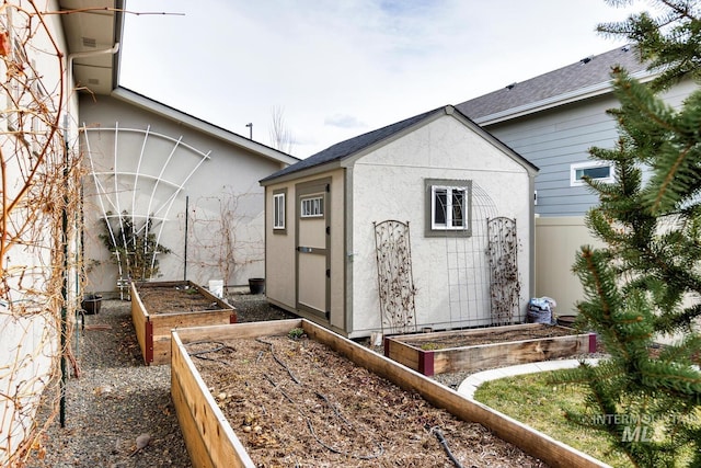 view of shed featuring fence and a vegetable garden