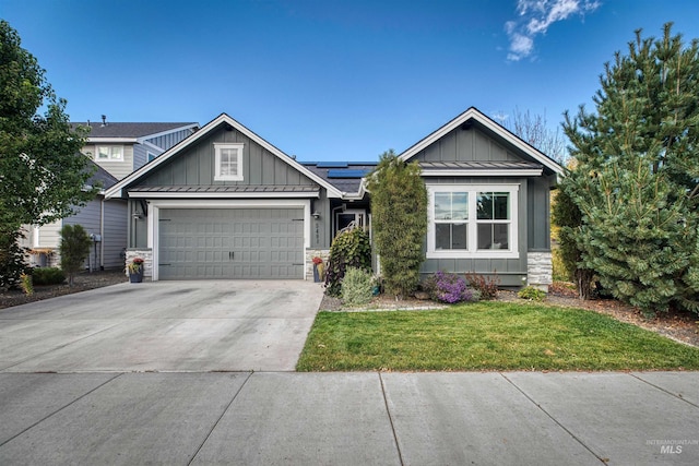 craftsman house with a garage, a front yard, and solar panels