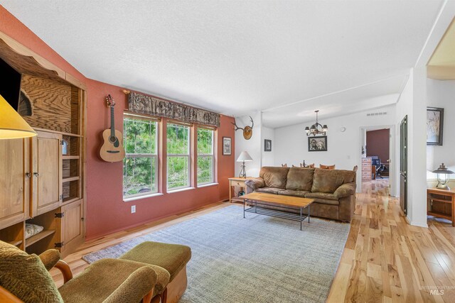 1745 Gibler Rd, Kamiah, ID 83536 - living area featuring light wood finished floors, a chandelier, and a textured ceiling