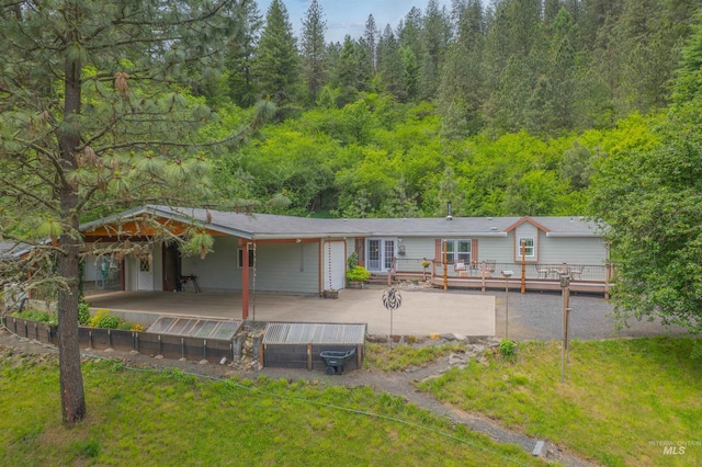 1745 Gibler Rd, Kamiah, ID 83536 - view of front of property with a deck, a front lawn, and a view of trees