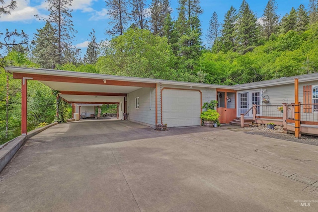 1745 Gibler Rd, Kamiah, ID 83536 - view of front of home with concrete driveway, a carport, a garage, a wooden deck, and french doors