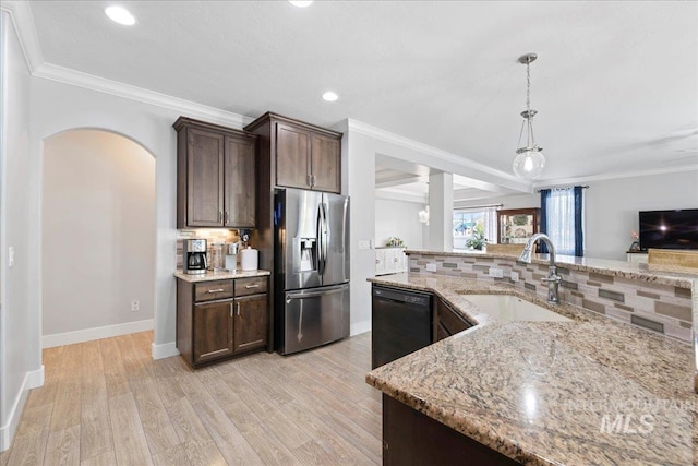 kitchen featuring dark brown cabinetry, a sink, stainless steel fridge with ice dispenser, black dishwasher, and decorative backsplash