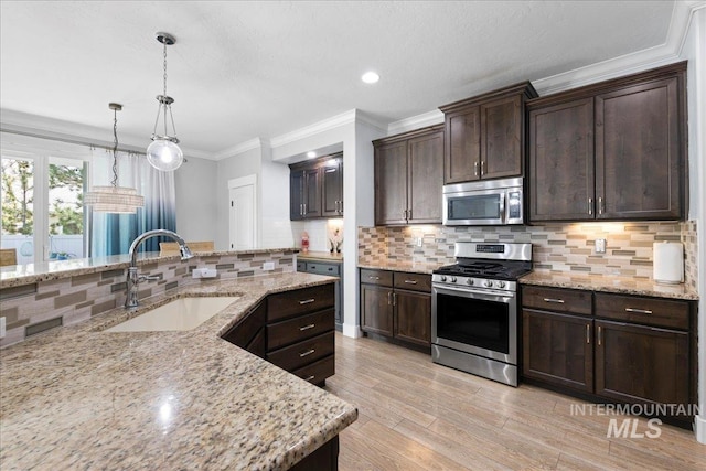 kitchen with backsplash, stainless steel appliances, a sink, and dark brown cabinets