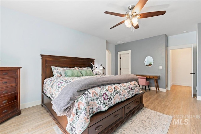 bedroom featuring baseboards, light wood finished floors, ceiling fan, and visible vents