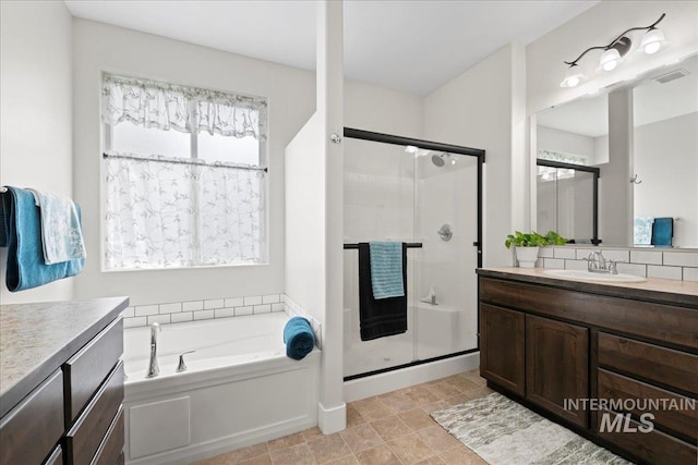 bathroom featuring visible vents, a garden tub, a stall shower, and vanity