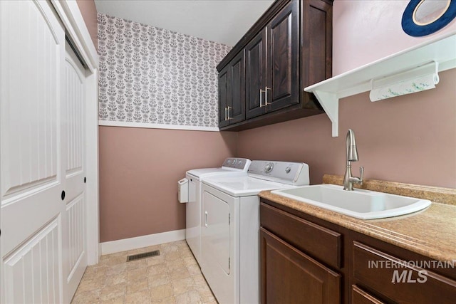 laundry room featuring visible vents, baseboards, separate washer and dryer, a sink, and cabinet space