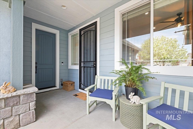 entrance to property with a porch and a ceiling fan