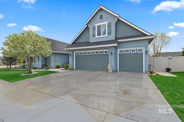 view of front of property featuring a garage, fence, a front yard, and concrete driveway