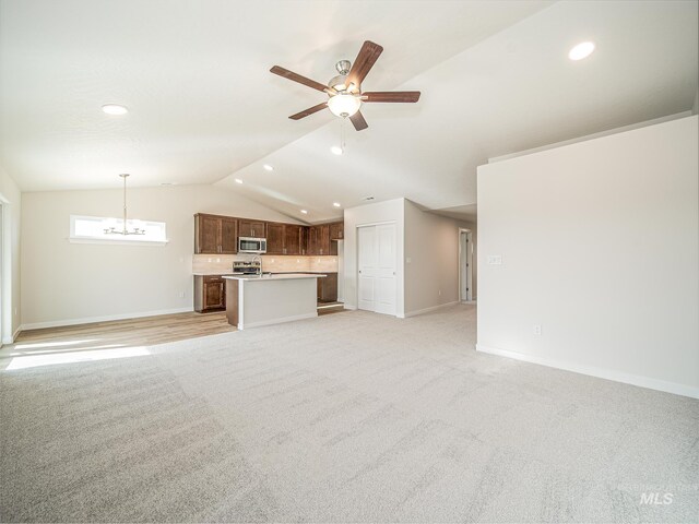 2314 E Cave Falls St, Kuna, ID 83634 - unfurnished living room featuring light carpet, lofted ceiling, recessed lighting, baseboards, and ceiling fan