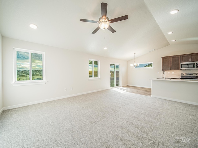 2314 E Cave Falls St, Kuna, ID 83634 - unfurnished living room featuring a sink, light colored carpet, lofted ceiling, a chandelier, and recessed lighting