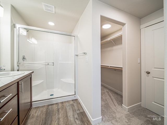 2314 E Cave Falls St, Kuna, ID 83634 - bathroom featuring a shower stall, a spacious closet, wood finished floors, and vanity