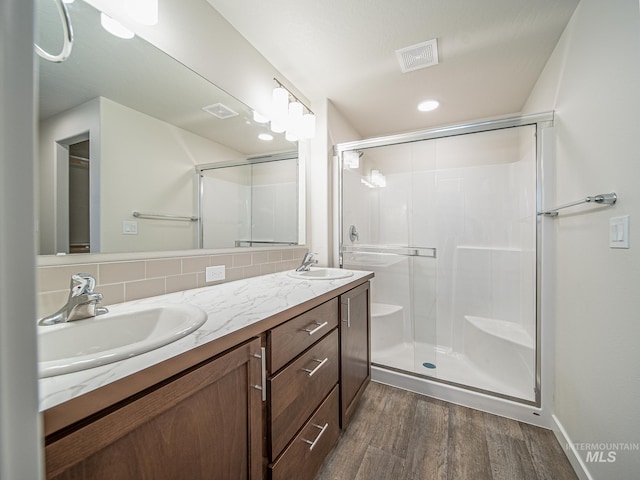 2314 E Cave Falls St, Kuna, ID 83634 - full bath featuring wood finished floors, a stall shower, double vanity, and tasteful backsplash