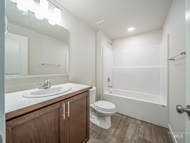 2314 E Cave Falls St, Kuna, ID 83634 - full bathroom with wood finished floors, toilet, tasteful backsplash, vanity, and shower / washtub combination