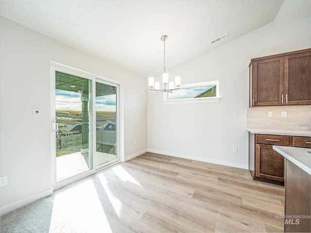 2314 E Cave Falls St, Kuna, ID 83634 - unfurnished dining area featuring vaulted ceiling, a chandelier, light wood-type flooring, and baseboards