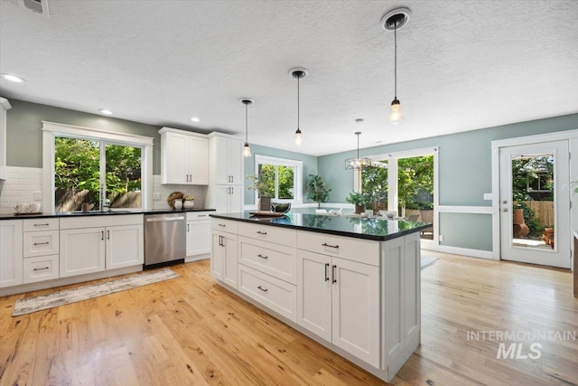1803 E Danmor Dr, Boise, ID 83712 - kitchen with dishwasher, light wood-style floors, a textured ceiling, plenty of natural light, and dark countertops