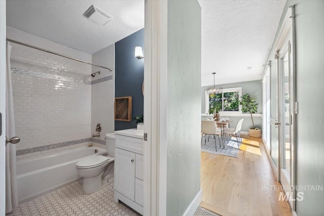 1803 E Danmor Dr, Boise, ID 83712 - full bath with bathing tub / shower combination, toilet, vanity, a textured ceiling, and a chandelier