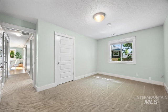 1803 E Danmor Dr, Boise, ID 83712 - unfurnished bedroom with light carpet, baseboards, a textured ceiling, and a closet