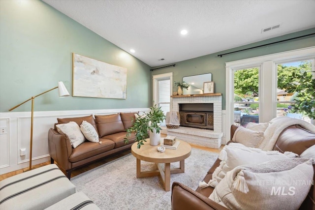1803 E Danmor Dr, Boise, ID 83712 - living area featuring a textured ceiling, a brick fireplace, wood finished floors, wainscoting, and recessed lighting