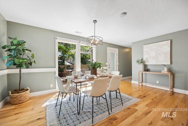 1803 E Danmor Dr, Boise, ID 83712 - dining space featuring light wood finished floors, a chandelier, and baseboards