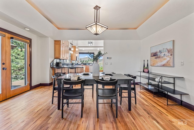 4997 N Brookside Ln, Boise, ID 83714 - dining room featuring a tray ceiling, light wood-style flooring, and baseboards