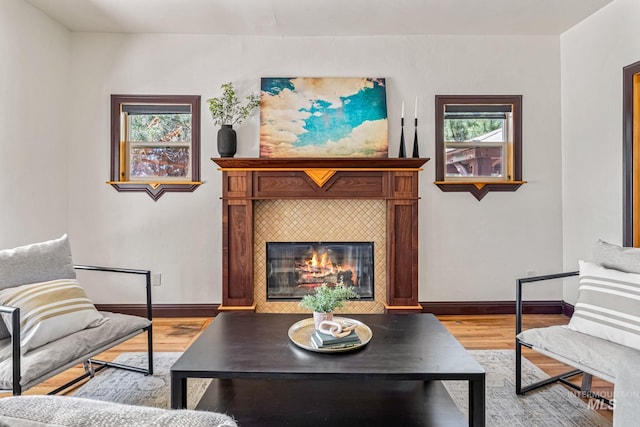 4997 N Brookside Ln, Boise, ID 83714 - living area featuring light wood finished floors, a tiled fireplace, and baseboards
