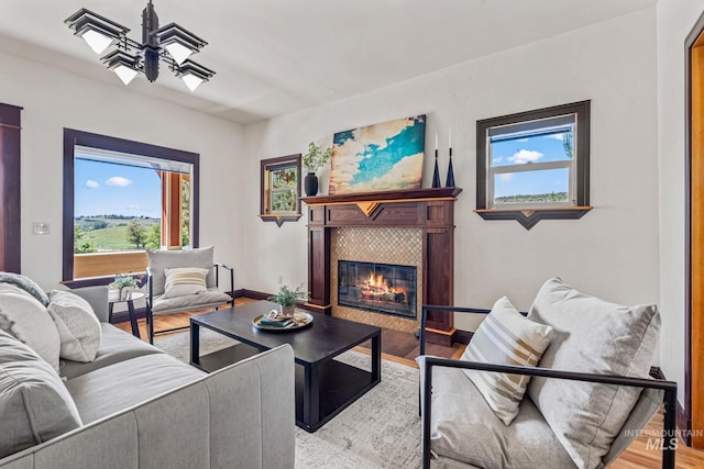 4997 N Brookside Ln, Boise, ID 83714 - living area with a tile fireplace, a chandelier, wood finished floors, and baseboards
