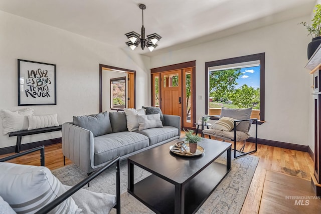 4997 N Brookside Ln, Boise, ID 83714 - living room with a chandelier, light wood-style flooring, and baseboards